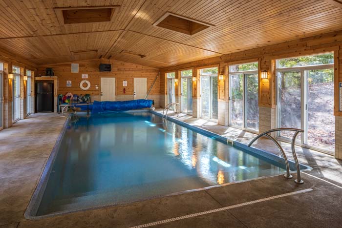 Indoor saltwater pool with handrails and pool cover at High Point Lodge