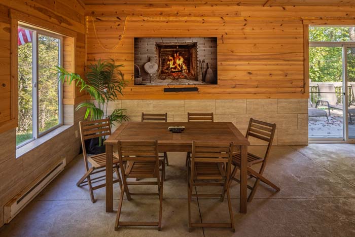 Pool house dining table with fireplace TV at High Point Lodge