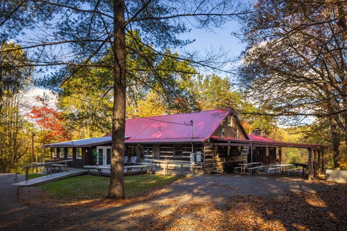 High Point Lodge log cabin with red roof among fall trees
