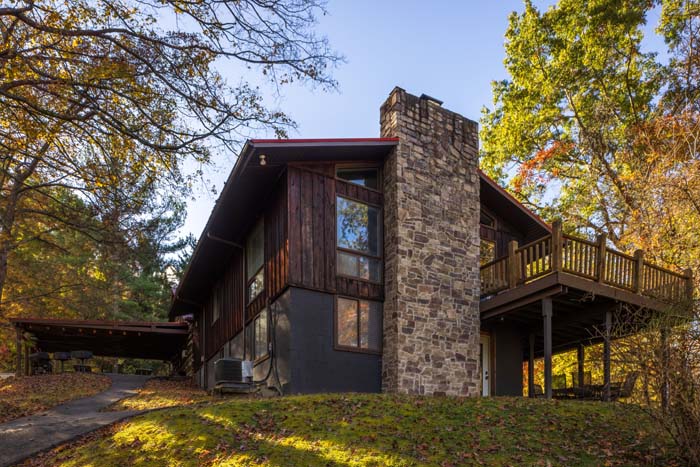 Lodge wing with stone chimney and upper deck in fall at High Point Lodge