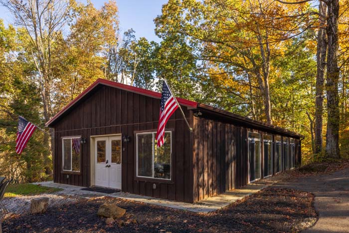 Pool house with red roof and American flags in fall at High Point Lodge