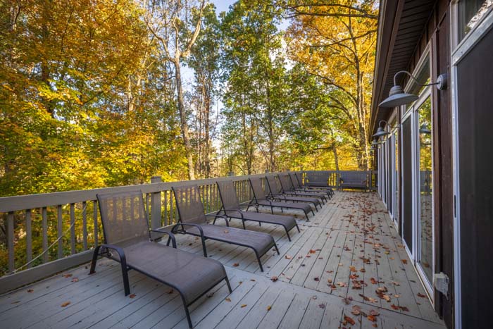Deck with lounge chairs overlooking the woods at High Point Lodge
