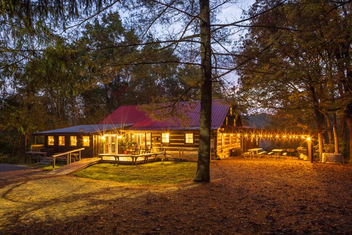 Log cabin lit with string lights at dusk at High Point Lodge