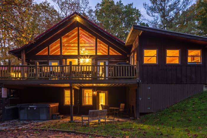 Lodge with glowing windows and decks at dusk at High Point Lodge