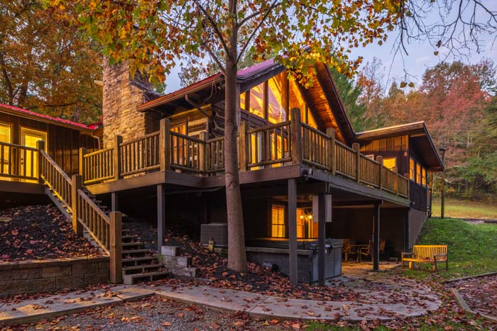Lodge with stone chimney, log railed decks and fall leaves at dusk at High Point Lodge