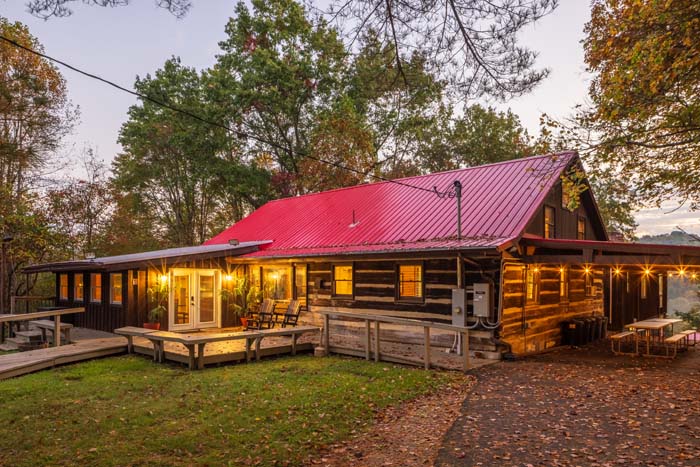 Log cabin with red roof lit at dusk at High Point Lodge