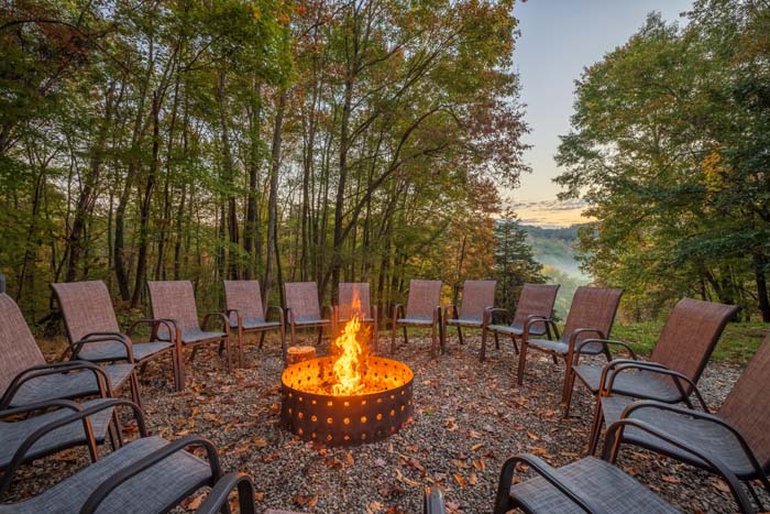 Fire pit burning with lounge chairs at sunset at High Point Lodge
