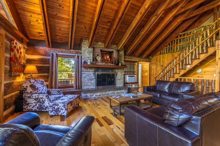Great room with leather sofas, stone fireplace and loft stairs at High Point Lodge