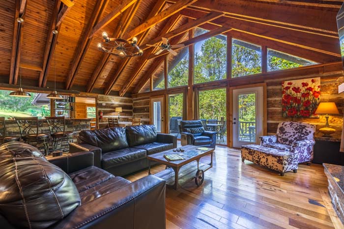 Great room with wall of windows, chandelier and leather seating at High Point Lodge
