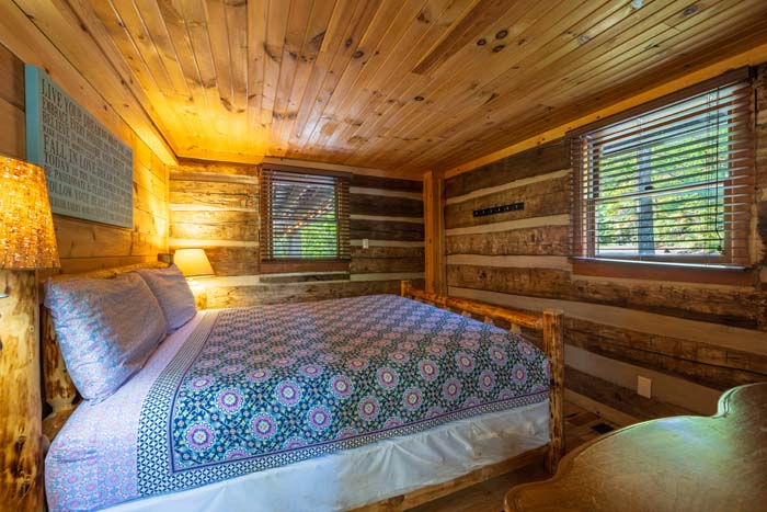 Bedroom with log bed and patterned quilt at High Point Lodge