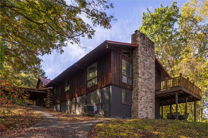 Two story lodge wing with stone chimney and upper deck at High Point Lodge