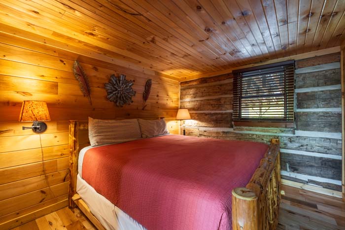 Bedroom with log bed and red quilt at High Point Lodge