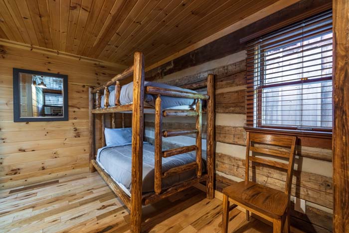 Log bunk beds and wood chair in the bunk room at High Point Lodge