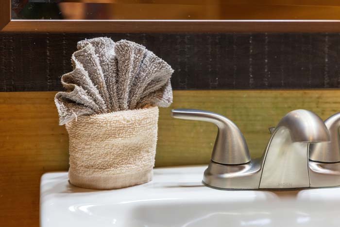 Folded hand towel in a basket by the bathroom faucet at High Point Lodge