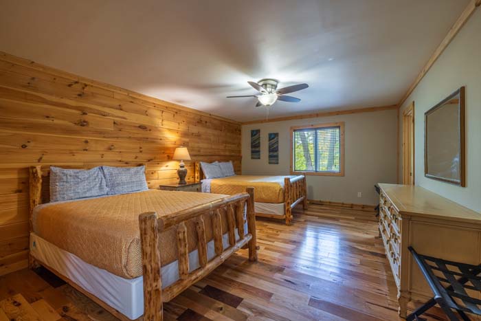 Bedroom with two queen log beds and ceiling fan at High Point Lodge