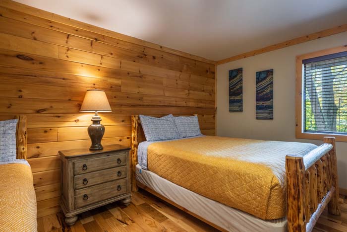 Bedroom with log bed, nightstand and lamp at High Point Lodge
