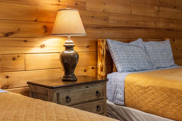Nightstand and lamp between two beds at High Point Lodge