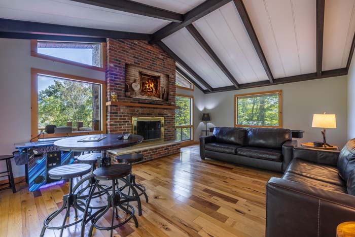Family room with brick fireplace, arcade table and leather sofas at High Point Lodge
