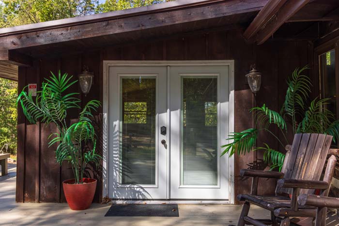 French door entrance with potted palms and rocking chairs at High Point Lodge