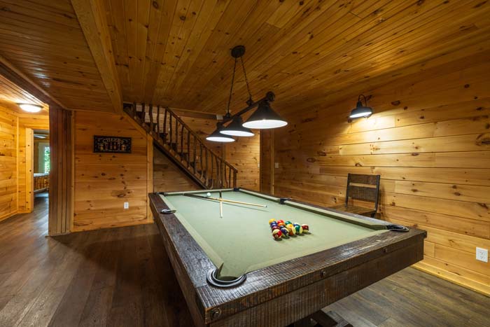 Pool table with racked balls by the stairs at High Point Lodge