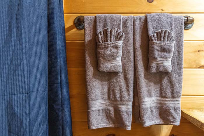 Bath towels hanging beside a blue shower curtain at High Point Lodge