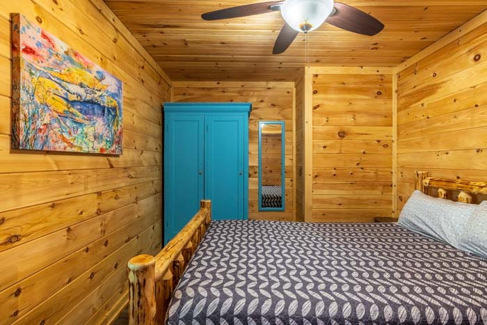 Log bed, teal armoire and colorful painting at High Point Lodge