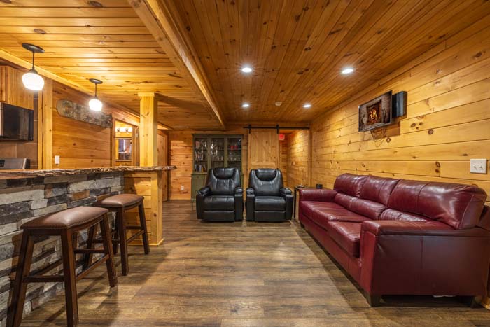 Lower level with stone bar, recliners and red leather sofa at High Point Lodge