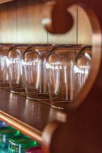 Wine glasses hanging under a wood cabinet at High Point Lodge