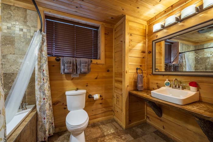 Bathroom with tub, toilet and vessel sink at High Point Lodge