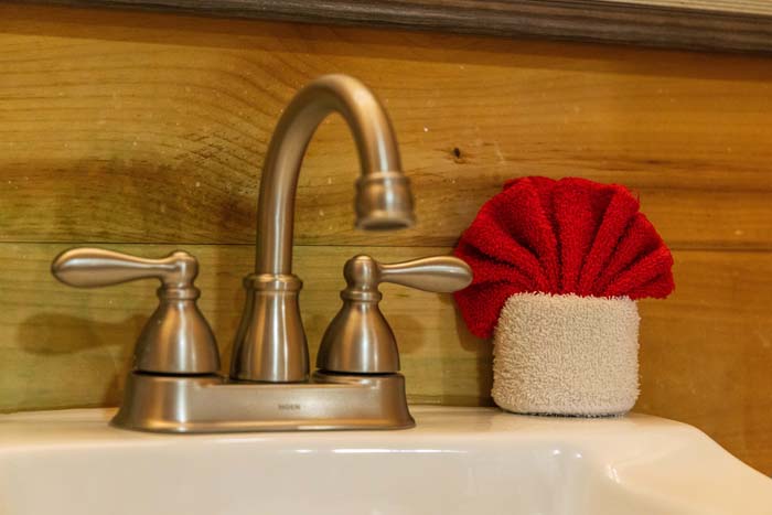 Brushed nickel faucet and folded red towel at High Point Lodge