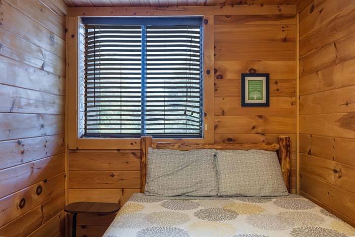 Bed under a window in a pine bedroom at High Point Lodge